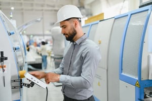 Insinyur industri yang tekun dan menggunakan tablet digital